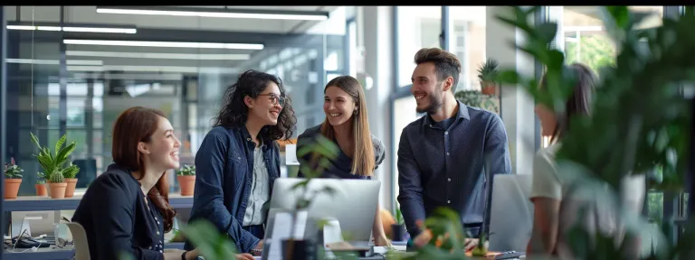 a group of employees smiling and working together in a modern office space.